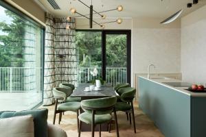 a dining room with a table and chairs and a kitchen at Maximilian Suites in Trieste