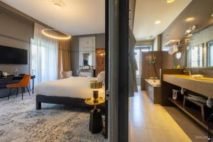 a hotel room with a bed and a bathroom at Le Champlain in La Rochelle
