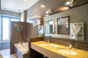 a bathroom with two sinks and a large mirror at Le Champlain in La Rochelle