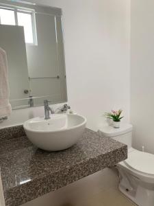a bathroom with a sink and a toilet at CasaMuyuyo - Hermosa Casa de Playa a 1h20 de Guayaquil in Playas