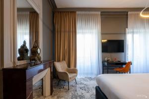 a hotel room with a bed and a desk and chair at Le Champlain in La Rochelle