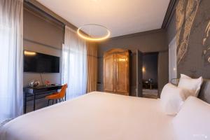 a bedroom with a large white bed and a desk at Le Champlain in La Rochelle