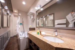 a bathroom with a sink and a large mirror at Le Champlain in La Rochelle