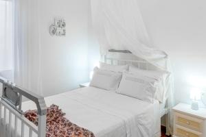 a white bed with white sheets and pillows in a bedroom at My Grandparents' Home in Ropanianá