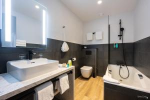 a bathroom with a sink and a tub and a toilet at Le Champlain in La Rochelle +34 photos