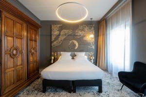 a bedroom with a large white bed and a chair at Le Champlain in La Rochelle