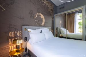 a bedroom with a large white bed and a mirror at Le Champlain in La Rochelle