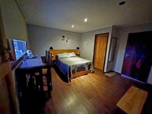 a bedroom with a bed and a wooden floor at LengaUsh in Ushuaia