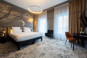 a hotel room with a bed and a desk at Le Champlain in La Rochelle