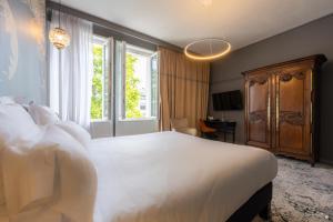 a bedroom with a large white bed and a window at Le Champlain in La Rochelle