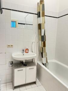 un bagno bianco con lavandino e vasca di AlPa 2 Zimmer Wohnung in Wien Rochusmarkt a Vienna