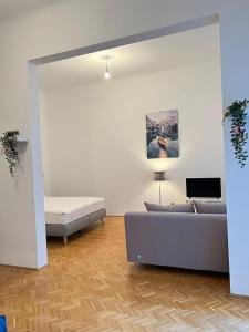 uma sala de estar com um sofá e uma cama em AlPa 2 Zimmer Wohnung in Wien Rochusmarkt em Viena