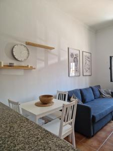 un soggiorno con divano blu e tavolo di Kgemelas a Telde