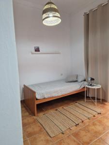 a bed in a room with a table and a lamp at Kgemelas in Telde