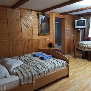 - une chambre avec un lit dans une pièce dotée de murs en bois dans l'établissement Guest House Grunyk, à Yaremtche