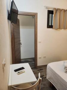 a room with a table and a tv on a wall at Aliga in Alghero