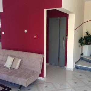 a living room with a couch and a red wall at Zefyros Hotel in Rhodes Town