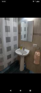 a bathroom with a white sink and mirror at Amaru Apart in La Consulta