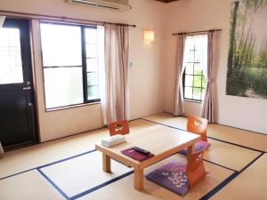 a living room with a table and chairs and windows at Awone Shirakami Juniko in Fukaura