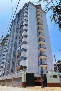 a tall building with people standing in front of it at Exquisite 1bedroom located in Garden Estate, Thome in Nairobi