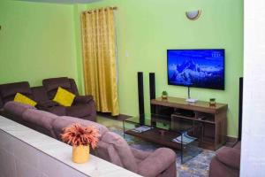 uma sala de estar com um sofá e uma televisão de ecrã plano em Exquisite 1bedroom located in Garden Estate, Thome em Nairobi