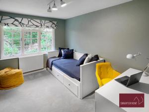 sypialnia z łóżkiem i biurkiem z laptopem w obiekcie Weybridge - 4 Bedroom Home - Driveway & Garden w mieście Walton-on-Thames