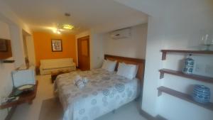 um quarto de hotel com uma cama e um sofá em 3 Palmeiras Guest Lounge em Miguel Pereira