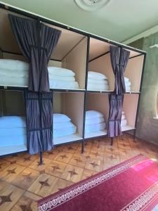 a room with bunk beds with curtains and a rug at Karvi Hostel & Suites in Batumi