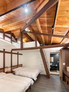 two beds in a room with wooden ceilings at Caolingdai BnB in Gukeng