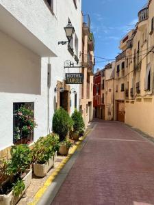 una calle vacía con una señal para un vestíbulo de hotel en Tarull en Tossa de Mar