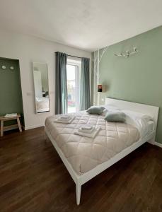 - un lit blanc dans une chambre avec fenêtre dans l'établissement Sotto al Bosco B&B e Azienda Agricola, à Dubino