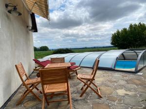 un patio con sillas y mesas y una piscina en Statek na samotě, en České Meziříčí