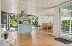 a kitchen and living room with a table and chairs at Holiday Home Karensvej in Grønhøj