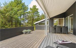 a wooden deck with chairs on a house at Nice Home In Lkken With 4 Bedrooms, Sauna And Wifi in Grønhøj