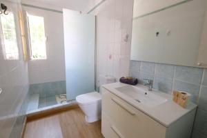 La salle de bains blanche est pourvue de toilettes et d'un lavabo. dans l'établissement MAKĀI Bungalows, à Playa del Aguila