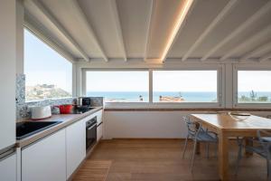 een keuken met een tafel en uitzicht op de oceaan bij Villa con Giardino Vista Mare in Castiglione della Pescaia