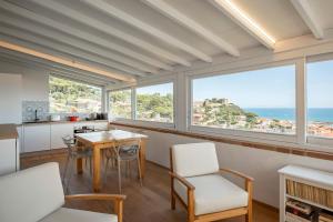 kuchnia ze stołem i krzesłami oraz oceanem w obiekcie Villa con Giardino Vista Mare w mieście Castiglione della Pescaia