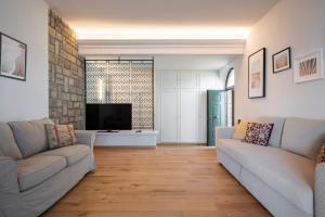 sala de estar con 2 sofás y TV de pantalla plana en Villa con Giardino Vista Mare en Castiglione della Pescaia