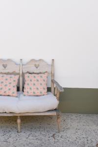 a bench with two pillows on it in a room at Vumba Agroturismo in Arganil