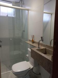 y baño con aseo, lavabo y ducha. en Rosa dos ventos suíte 1, en Florianópolis