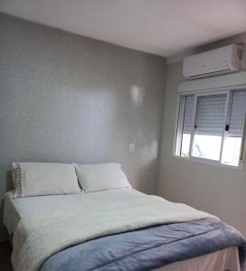 1 cama en un dormitorio con ventana en Rosa dos ventos suíte 1, en Florianópolis