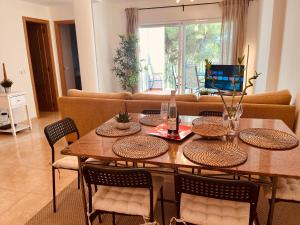 y sala de estar con mesa de comedor y sillas. en Arenal Dream Javea, luxury beach apartment, en Jávea