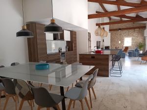 eine Küche und ein Esszimmer mit einem Tisch und Stühlen in der Unterkunft Maison de Charme - Maréchalerie - Nîmes in Uchaud