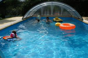 trójka dzieci bawiących się w basenie w obiekcie Domek Olmonty w mieście Białystok