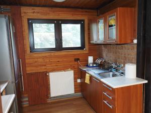 małą kuchnię ze zlewem i oknem w obiekcie Domek Olmonty w mieście Białystok