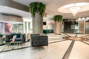 a lobby with two chairs and a table and columns at Zdravets SPA Hotel in Velingrad