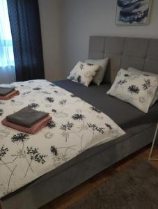 a bed with a comforter and pillows on it at Apartman NOA EXCLUSIVE in Trebinje
