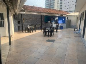 a patio with tables and chairs and a building at Pousada Aconchego Ocian in Praia Grande