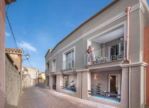 a woman standing on the balcony of a building at MEM Lodge and Suite in Pula