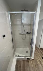 una doccia con porta in vetro in bagno di Bienvenue chez Tom a Lamballe